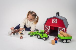 Menina brincando com mini-fazendinha
